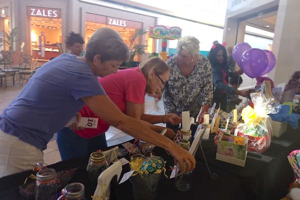 People looking at the raffle items at the Artisans at the Mall event.