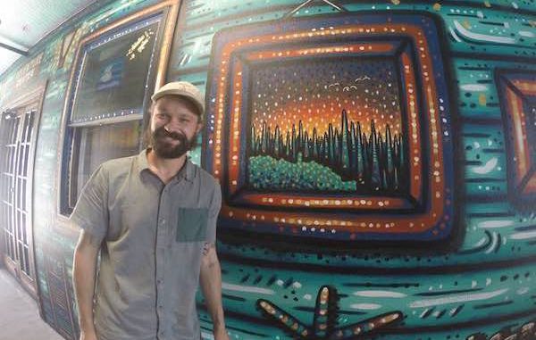 Nick Fisher, an artist from Sebastian, paints a mural at the Captain Hiram's Resort.