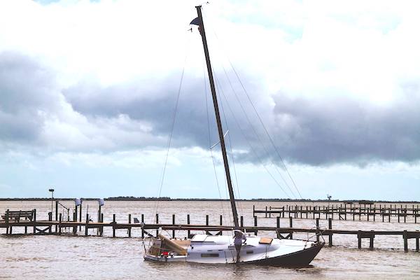 Someone removing items from the sailboat after the storm.