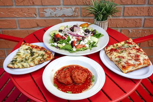 Slice of Sicilian pizza, slice of broccoli rabe pizza, meatballs and a Greek salad.