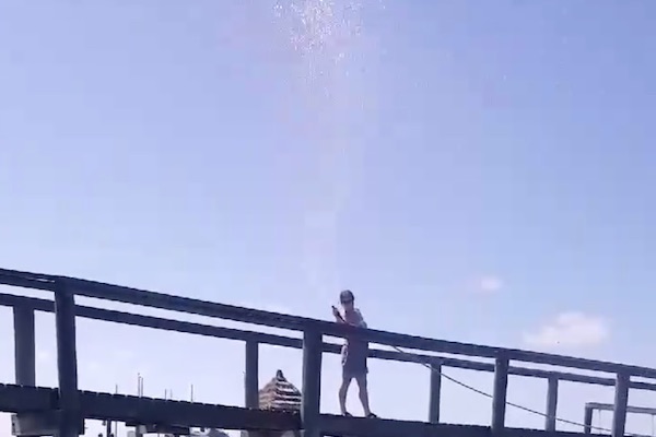 Joyce Khatibi sprays Jose Ortiz with water from her dock. 