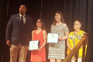 Sebastian River High School Principle Dariyall Brown awards Stephanie Giordano and Reagan O'Rourke scholarships with a representative from The Lions club.