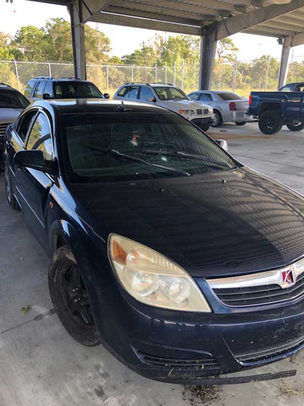 Crime scene photos of vehicle with bullet holes.