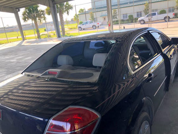 Crime scene photos of vehicle with bullet holes.