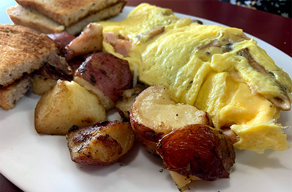 Ham, mushroom, and cheese omelet with home fries and rye toast.