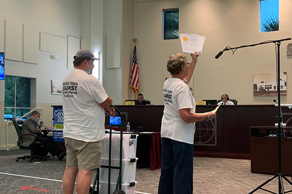 Tracey Cole, founder of the Sebastian Voters Against Gilliams and Parris PAC, shows the first round of signed petitions to recall Charles Mauti, Damien Gilliams, and Pamela Parris.