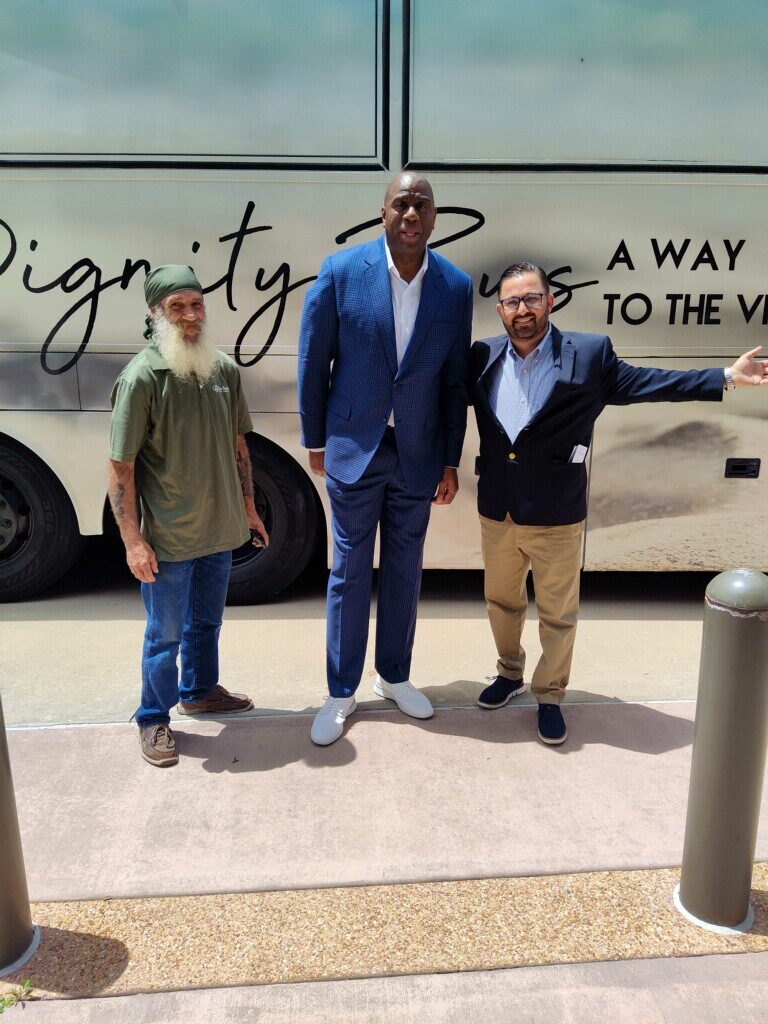 Standing in front of the Indian River County Dignity Bus, (left to right) Bus Driver Kyle, Magic Johnson and Anthony Zorbaugh. When touring the bus Johnson shared how great the Bus was and wished there were some in Los Angeles.