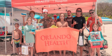 Orlando Health volunteers and members of Sober Surfers engaged with community members at the Orlando Health tent during the Longest Day, Longest Ride Surf Contest at Sebastian Inlet, hosted by the Sebastian Chamber of Commerce and held at Sebastian Inlet on Sunday, June 21. Orlando Health sponsored nine Sober Surfers participants in the contest, where surfer Brad Lee (pictured, fourth from left) won first place. Orlando Health team member Victor Rodriguez served as a judge, while additional team members distributed sunscreen and beach balls and raffled off a boombox and beach chairs. The family-friendly event raised funds and awareness for Alzheimer’s disease.